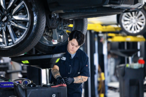 Factory-trained dealership technician performing an oil service on a vehicle.